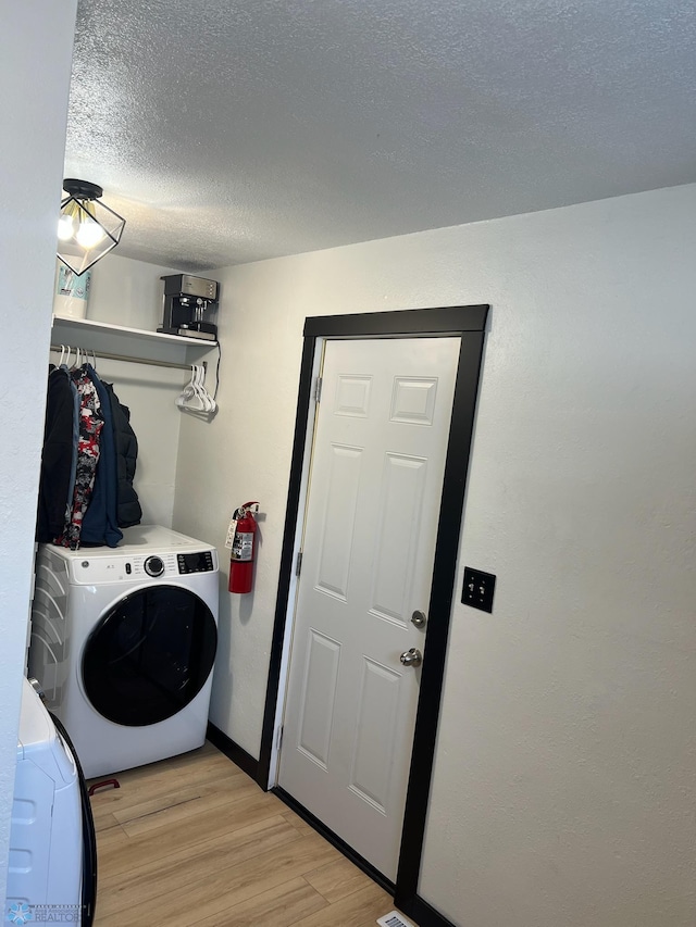 1822 7th Ave S, Fargo, ND 58103 - laundry room with light wood-style flooring, a textured ceiling, and washer and clothes dryer