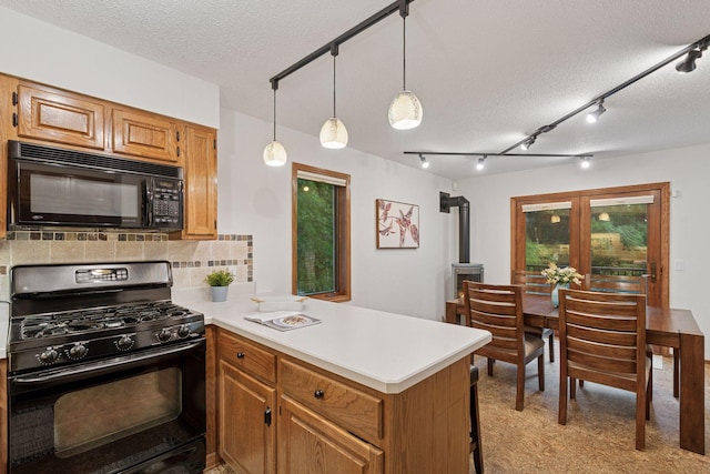 729 Summit Ave, Saint Paul, MN 55105 - kitchen featuring black appliances, a peninsula, a textured ceiling, light countertops, and decorative backsplash