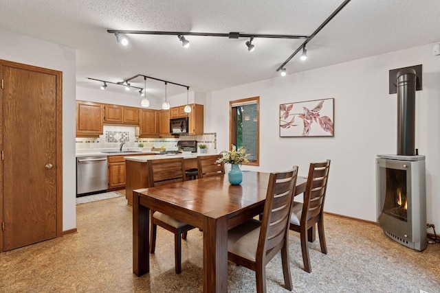 729 Summit Ave, Saint Paul, MN 55105 - dining space featuring track lighting, a wood stove, and a textured ceiling