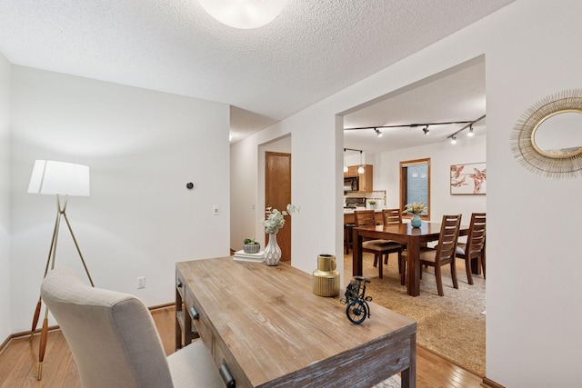 729 Summit Ave, Saint Paul, MN 55105 - dining room with light wood-type flooring, rail lighting, and a textured ceiling