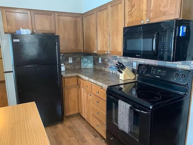 5960 165th St NE, Atwater, MN 56209 - kitchen with black appliances, light wood finished floors, and tasteful backsplash