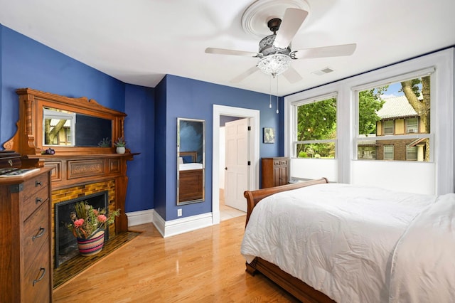 977 Portland Ave Unit 1, Saint Paul, MN 55104 - bedroom with a brick fireplace, light wood-style floors, and a ceiling fan