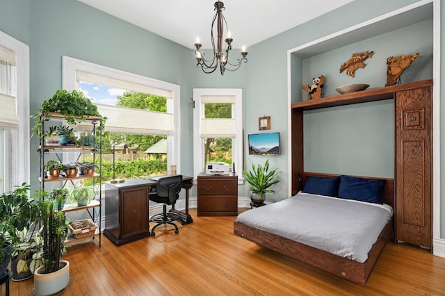 977 Portland Ave Unit 1, Saint Paul, MN 55104 - bedroom with light wood finished floors, a chandelier, and an office area