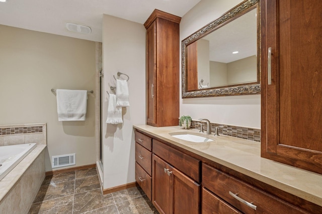 7516 Colorado Ave N, Brooklyn Park, MN 55443 - bathroom with vanity, a bath, a stall shower, and stone finish flooring