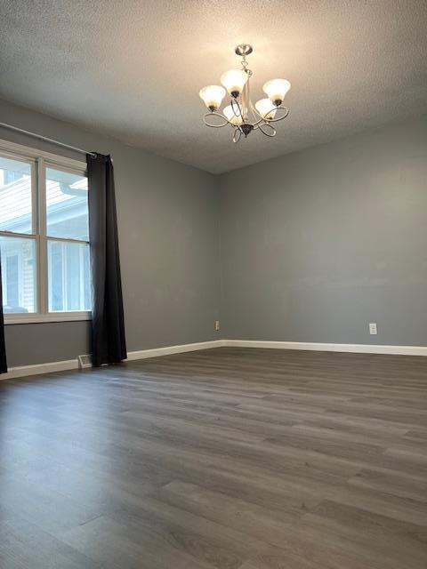 4918 Grenwich Trl N, Oakdale, MN 55128 - spare room with a chandelier, dark wood-style flooring, and a textured ceiling