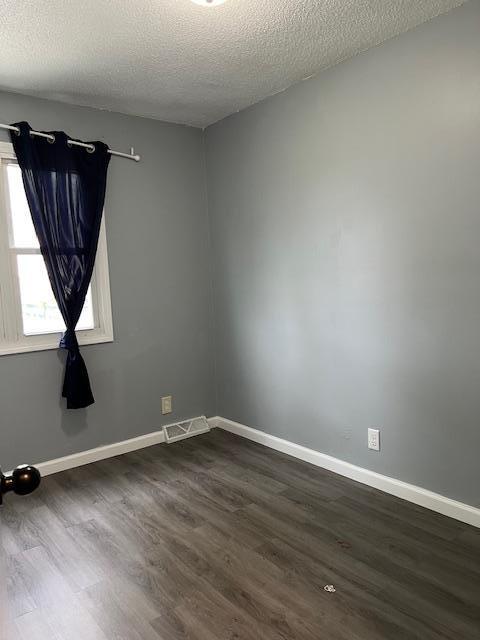 4918 Grenwich Trl N, Oakdale, MN 55128 - unfurnished room with a textured ceiling and dark wood-style flooring