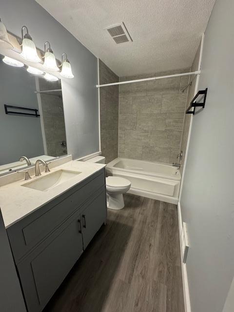 4918 Grenwich Trl N, Oakdale, MN 55128 - bathroom featuring a textured ceiling, wood finished floors, vanity, and shower / washtub combination