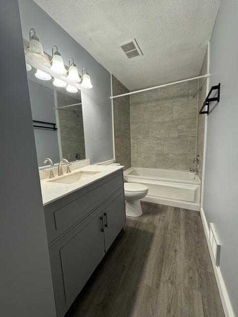 4918 Grenwich Trl N, Oakdale, MN 55128 - full bathroom with a textured ceiling, wood finished floors, vanity, and  shower combination