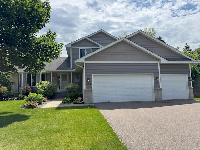 402 14th St, Delano, MN 55328 - craftsman inspired home featuring asphalt driveway, brick siding, a front lawn, and an attached garage
