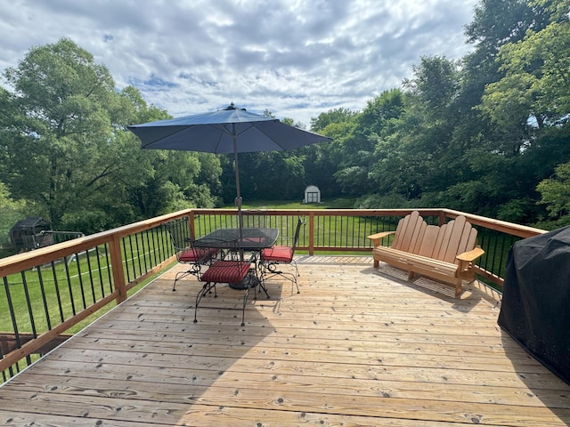 402 14th St, Delano, MN 55328 - wooden terrace featuring outdoor dining area, a lawn, a grill, and view of scattered trees