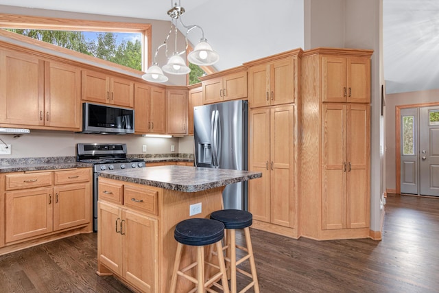 22027 Ethan Ave, Forest Lake, MN 55025 - kitchen featuring appliances with stainless steel finishes, dark countertops, dark wood finished floors, a center island, and light brown cabinets