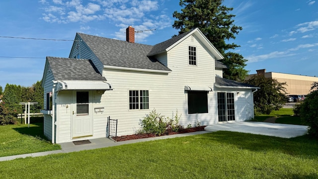 112 4th St E, Park Rapids, MN 56470 - rear view of property with a shingled roof, a chimney, a yard, and a patio