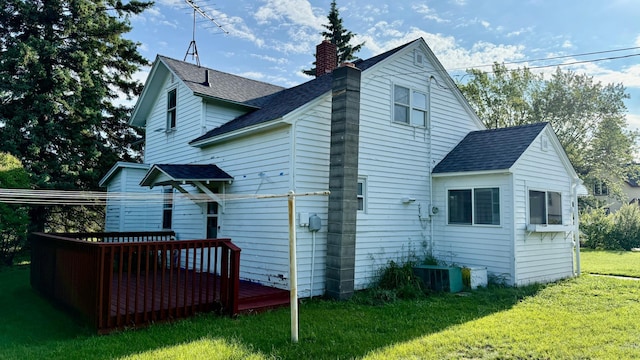 112 4th St E, Park Rapids, MN 56470 - back of property featuring a lawn, a deck, a shingled roof, and a chimney