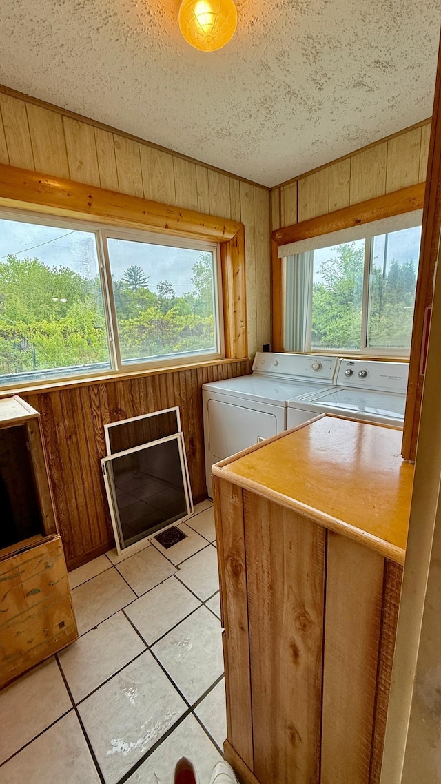 112 4th St E, Park Rapids, MN 56470 - laundry room with washing machine and dryer, wooden walls, a textured ceiling, and light tile patterned flooring