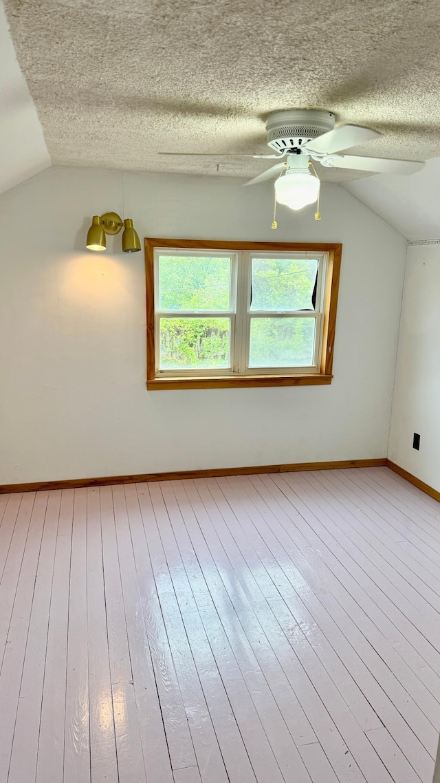 112 4th St E, Park Rapids, MN 56470 - empty room with lofted ceiling, hardwood / wood-style flooring, a textured ceiling, a ceiling fan, and plenty of natural light