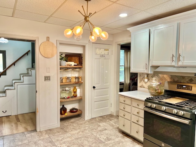 410 10th St SW, Willmar, MN 56201 - kitchen with gas range, a chandelier, light countertops, a paneled ceiling, and pendant lighting