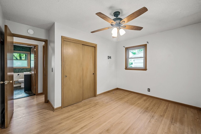 6121 Trinity Dr NE, Fridley, MN 55432 - unfurnished bedroom featuring light wood-type flooring, a closet, a textured ceiling, and ceiling fan