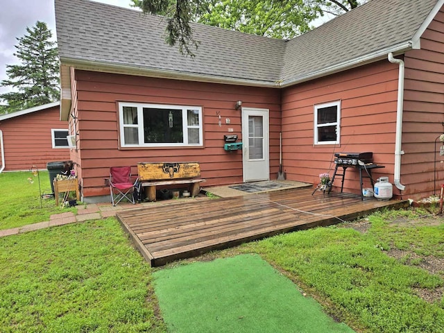 607 Riverside Ave, Park Rapids, MN 56470 - back of house featuring a wooden deck, roof with shingles, and a lawn