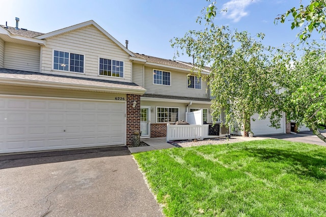6226 Maclynn Ave NE, Otsego, MN 55301 - view of front of home with a front yard, brick siding, asphalt driveway, and a shingled roof