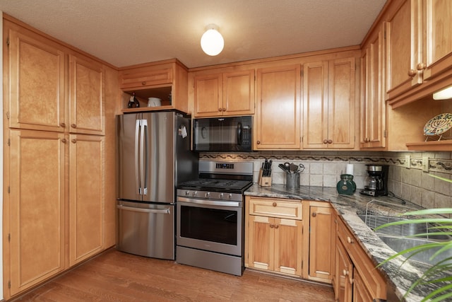 1163 Edgcumbe Rd Unit 1163, Saint Paul, MN 55105 - kitchen with appliances with stainless steel finishes, open shelves, backsplash, light wood finished floors, and a textured ceiling