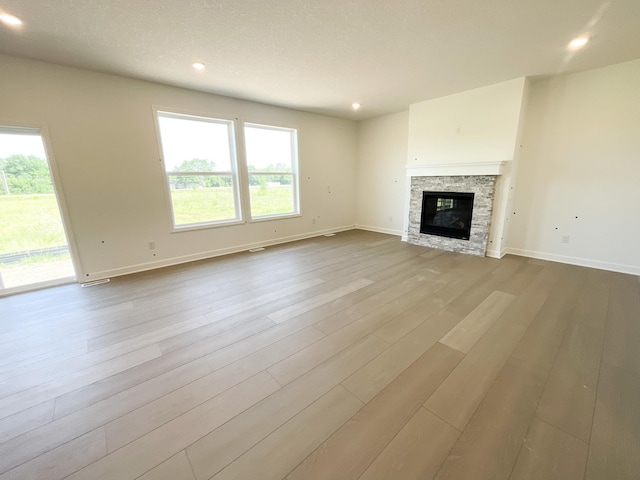 5890 Rathbun Ave NE, Otsego, MN 55374 - unfurnished living room with wood finished floors, recessed lighting, and a fireplace