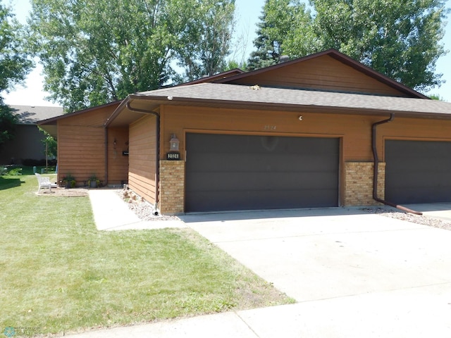 2524 25th Ave S, Fargo, ND 58103 - view of front of house featuring brick siding, concrete driveway, a front yard, a garage, and a shingled roof