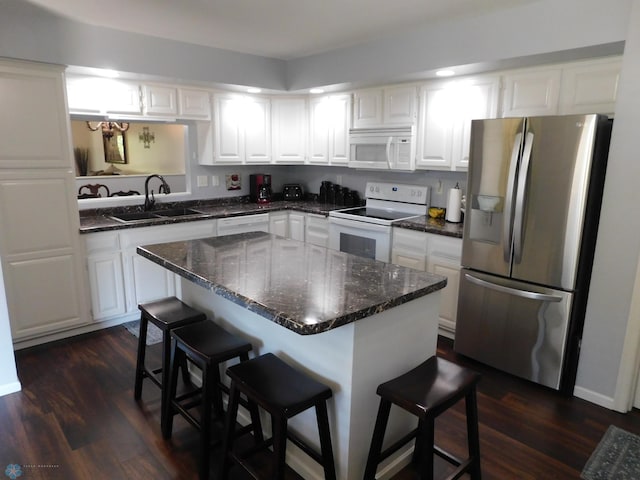 2524 25th Ave S, Fargo, ND 58103 - kitchen with white appliances, a kitchen bar, white cabinets, and dark wood finished floors