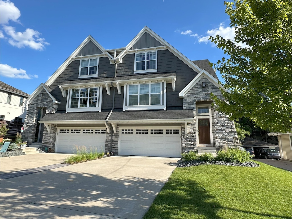 3927 49th St, Edina, MN 55424 - view of front of house with stone siding, concrete driveway, an attached garage, and a front lawn