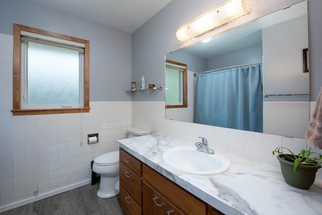 1704 Fair St, Mankato, MN 56001 - bathroom featuring tile walls, wood finished floors, vanity, wainscoting, and a shower with curtain
