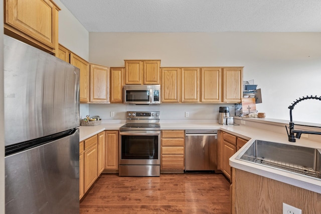 20060 Heritage Dr, Lakeville, MN 55044 - kitchen with appliances with stainless steel finishes, light brown cabinets, light countertops, dark wood-style floors, and a peninsula