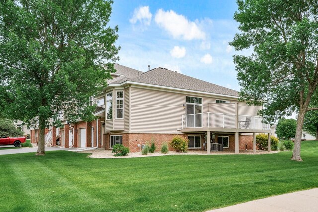 20060 Heritage Dr, Lakeville, MN 55044 - rear view of house featuring brick siding, a yard, driveway, a shingled roof, and an attached garage