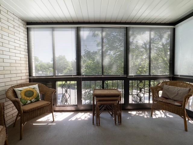 2720 Dale St N Unit C206, Roseville, MN 55113 - sunroom with carpet, brick wall, and a wall of windows