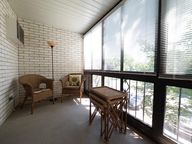 2720 Dale St N Unit C206, Roseville, MN 55113 - sunroom / solarium featuring brick wall and carpet flooring