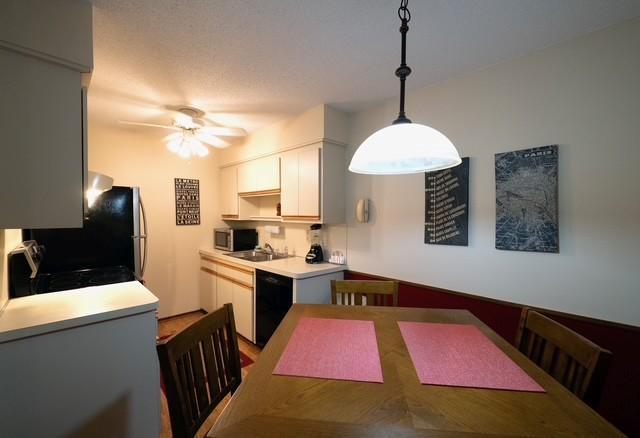 2720 Dale St N Unit C206, Roseville, MN 55113 - kitchen featuring black appliances, light countertops, a ceiling fan, white cabinetry, and decorative light fixtures