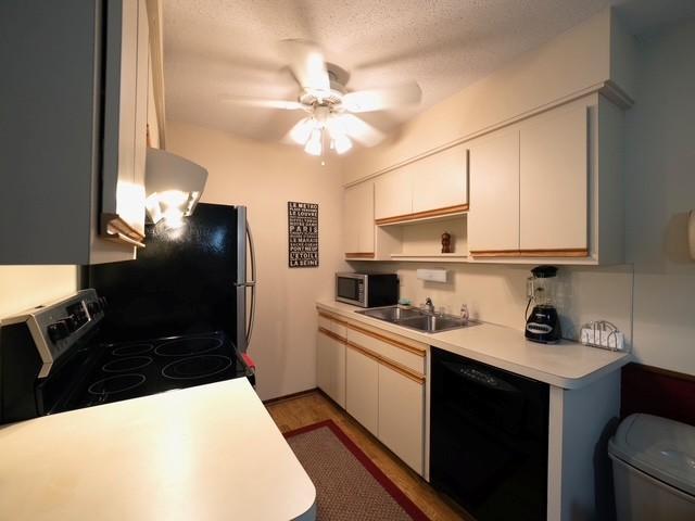 2720 Dale St N Unit C206, Roseville, MN 55113 - kitchen featuring black dishwasher, electric range, freestanding refrigerator, light countertops, and a ceiling fan