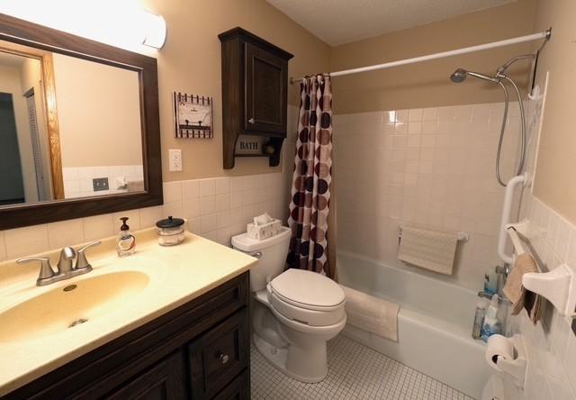 2720 Dale St N Unit C206, Roseville, MN 55113 - bathroom featuring tile walls, vanity, shower / bath combo, a wainscoted wall, and tile patterned floors