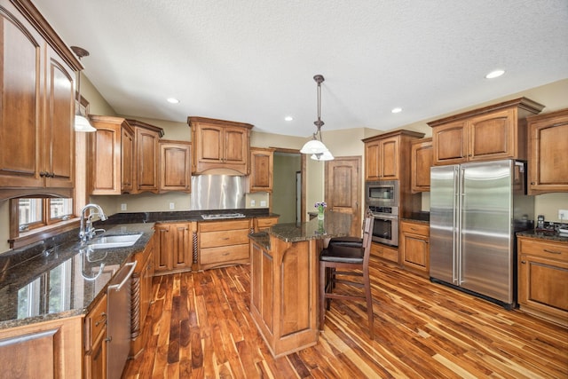 18658 Ponderosa Ct, Eden Prairie, MN 55347 - kitchen with stainless steel appliances, dark wood-style flooring, brown cabinetry, a breakfast bar, and a center island