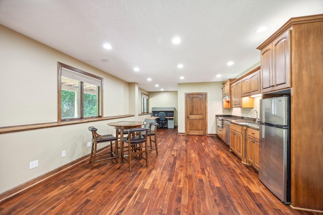 18658 Ponderosa Ct, Eden Prairie, MN 55347 - kitchen with appliances with stainless steel finishes, dark wood finished floors, recessed lighting, dark countertops, and brown cabinets