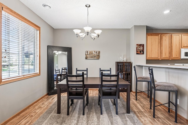 14220 Avalon Path Unit 1102, Rosemount, MN 55068 - dining area with light wood-style floors, a chandelier, and a textured ceiling