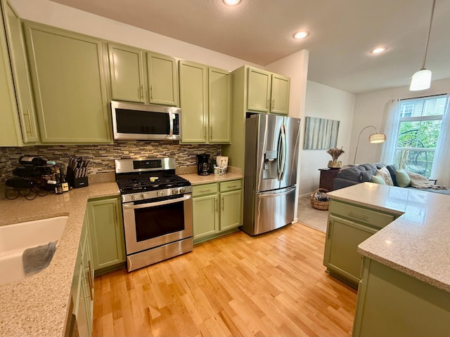 8124 Oakview Ln N Unit 47, Maple Grove, MN 55369 - kitchen featuring appliances with stainless steel finishes, green cabinets, decorative backsplash, light wood-type flooring, and recessed lighting