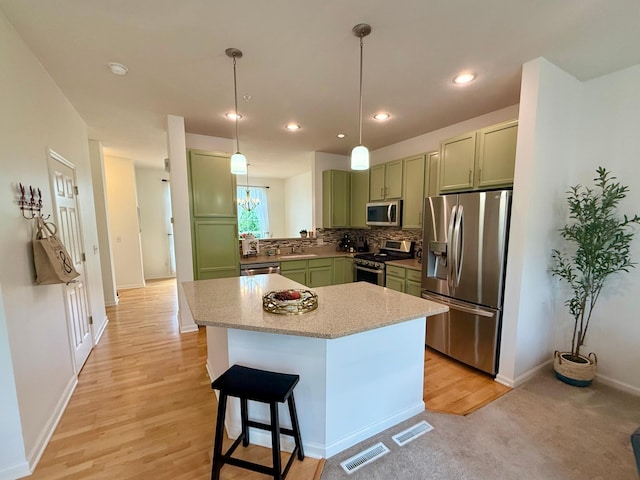 8124 Oakview Ln N Unit 47, Maple Grove, MN 55369 - kitchen with stainless steel appliances, green cabinets, light wood finished floors, decorative backsplash, and pendant lighting