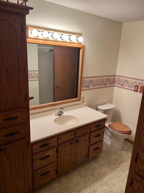 324 7th St, Windom, MN 56101 - bathroom featuring a wainscoted wall, vanity, a textured ceiling, and tile patterned floors