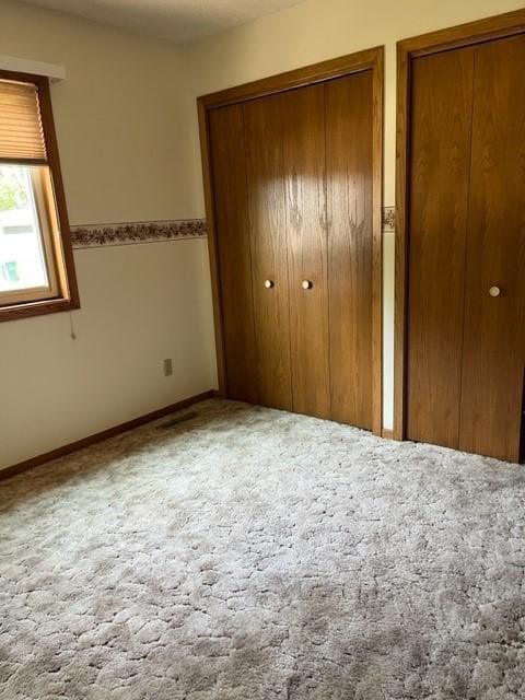 324 7th St, Windom, MN 56101 - unfurnished bedroom featuring carpet floors and two closets