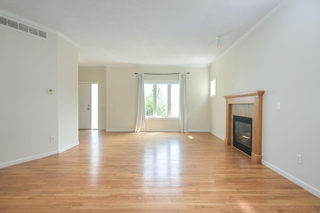 12344 67th St NE, Otsego, MN 55330 - unfurnished living room with crown molding, a tile fireplace, and light wood-style flooring