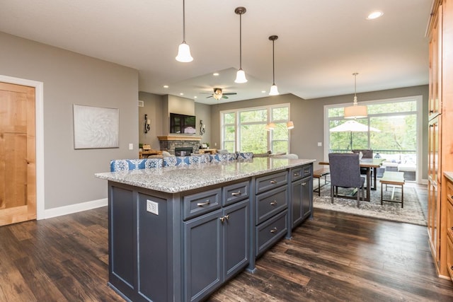 29680 Hidden Forest Blvd, Chisago City, MN 55013 - kitchen with dark wood-type flooring, a ceiling fan, a fireplace, recessed lighting, and light stone counters