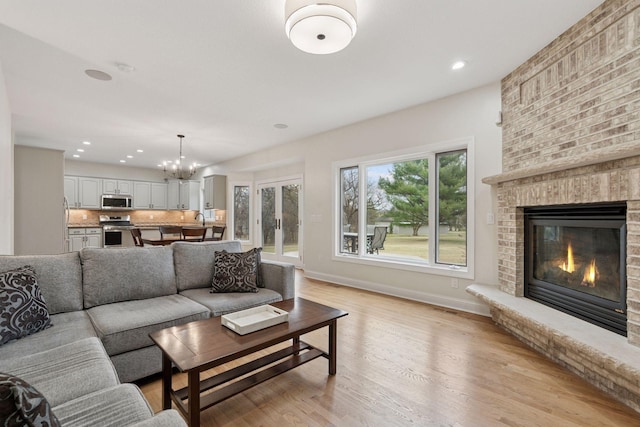 4584 162nd Ln NW, Andover, MN 55304 - living area with a brick fireplace, a chandelier, light wood finished floors, and recessed lighting