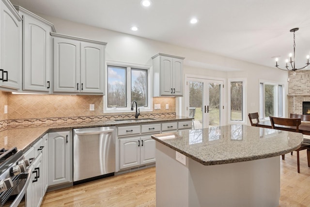 4584 162nd Ln NW, Andover, MN 55304 - kitchen featuring stainless steel appliances, light stone counters, light wood-type flooring, a chandelier, and recessed lighting
