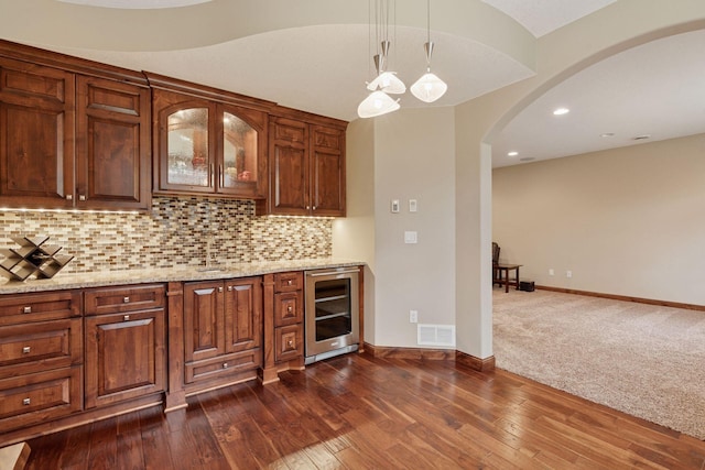 4584 162nd Ln NW, Andover, MN 55304 - bar area featuring wine cooler, arched walkways, backsplash, hanging light fixtures, and dark wood finished floors