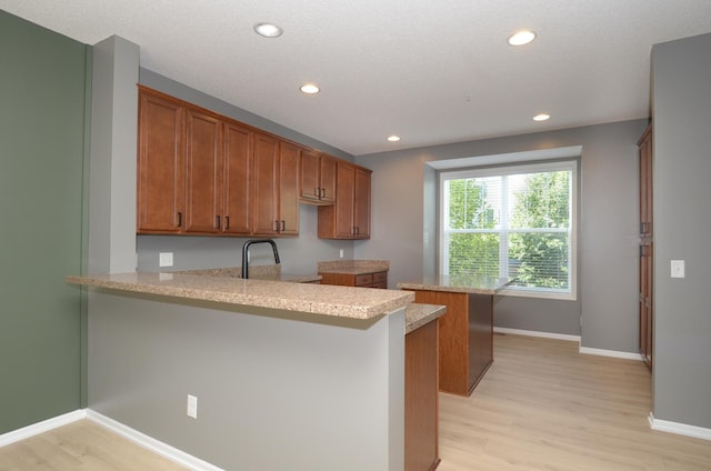 8397 Norwood Ln N, Maple Grove, MN 55311 - kitchen with a peninsula, light wood-style floors, recessed lighting, and brown cabinetry