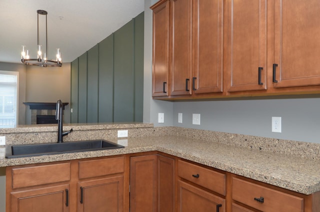 8397 Norwood Ln N, Maple Grove, MN 55311 - kitchen featuring brown cabinets, decorative light fixtures, a chandelier, and light stone countertops
